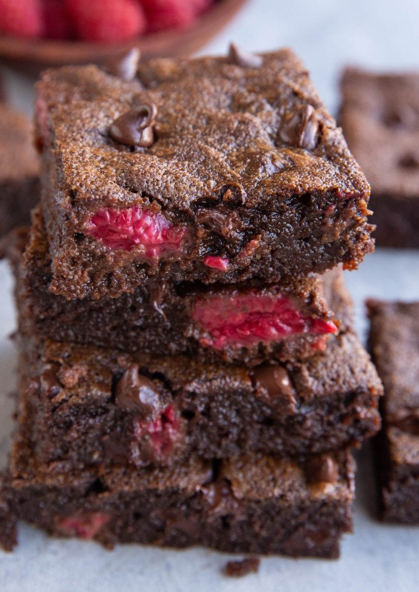 Stack of four raspberry brownies, exposing their fudgy middle. Ready to enjoy!