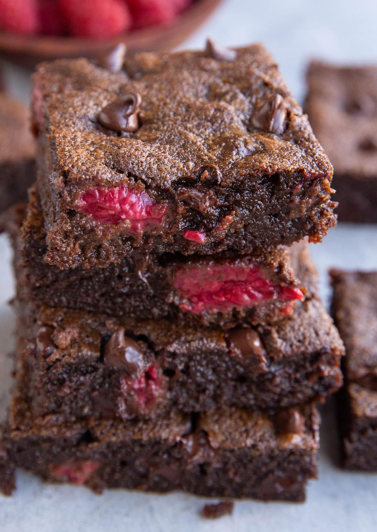 Stack of four raspberry brownies, exposing their fudgy middle. Ready to enjoy!