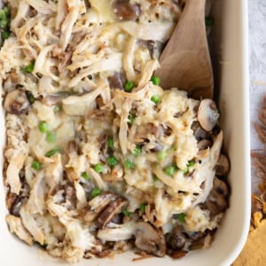Large casserole dish full of rotisserie chicken casserole with a wooden spoon to the side, ready to serve.