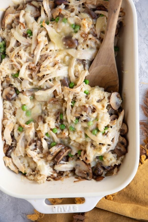 Large casserole dish full of rotisserie chicken casserole with a wooden spoon to the side, ready to serve.