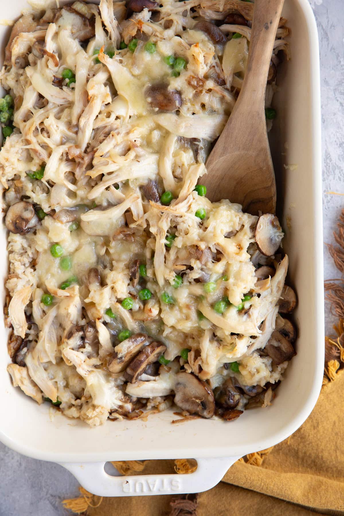 Large casserole dish full of rotisserie chicken casserole with a wooden spoon to the side, ready to serve.