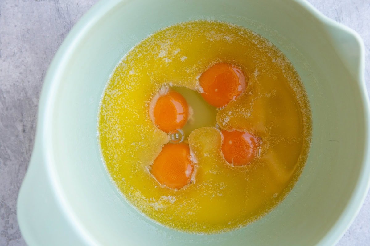 Mixing bowl with melted butter and eggs, ready to be mixed together.