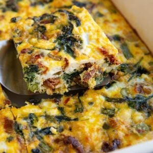 Breakfast Casserole in a casserole dish with a slice taken out so you can see the inside.