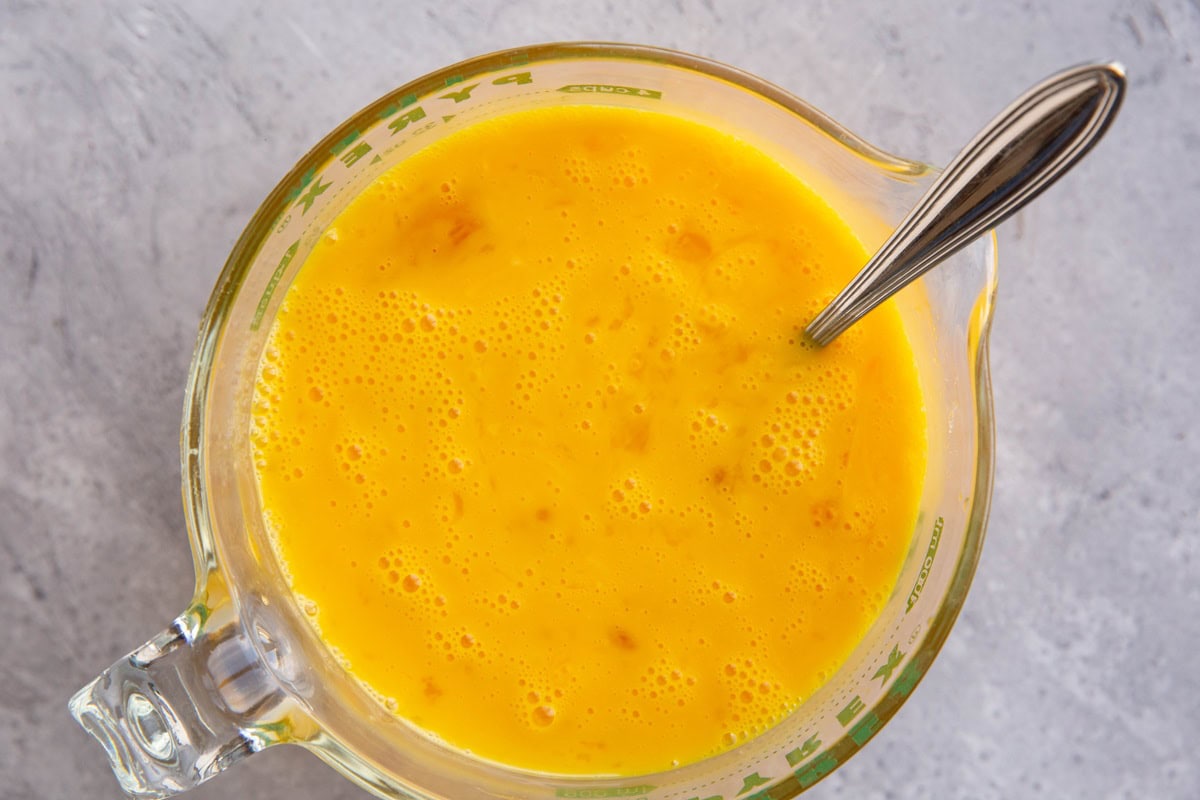 large measuring cup full of beaten eggs.