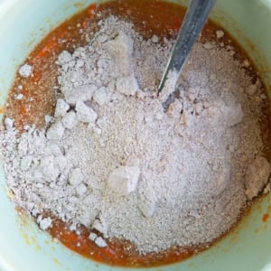 Dry ingredients on top of wet ingredients in a mixing bowl.