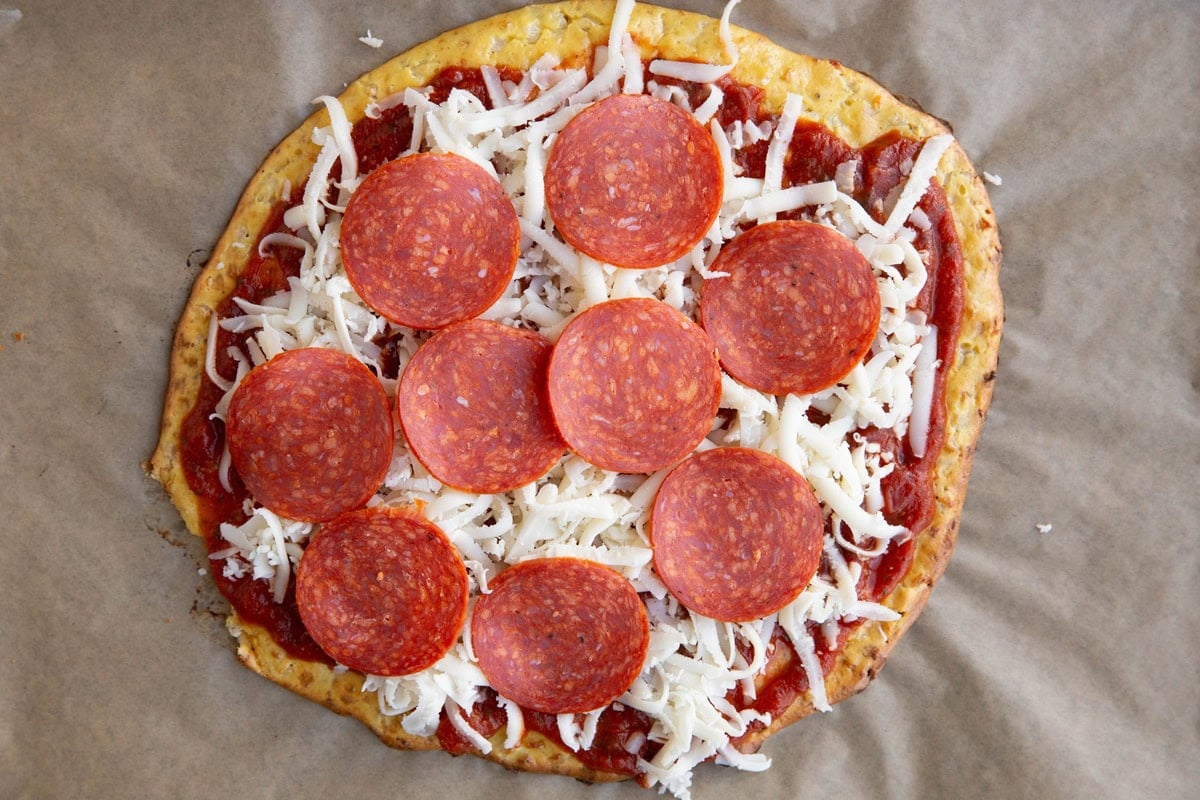 Pizza crust with sauce, grated cheese and pepperoni, ready to go into the oven to cook.