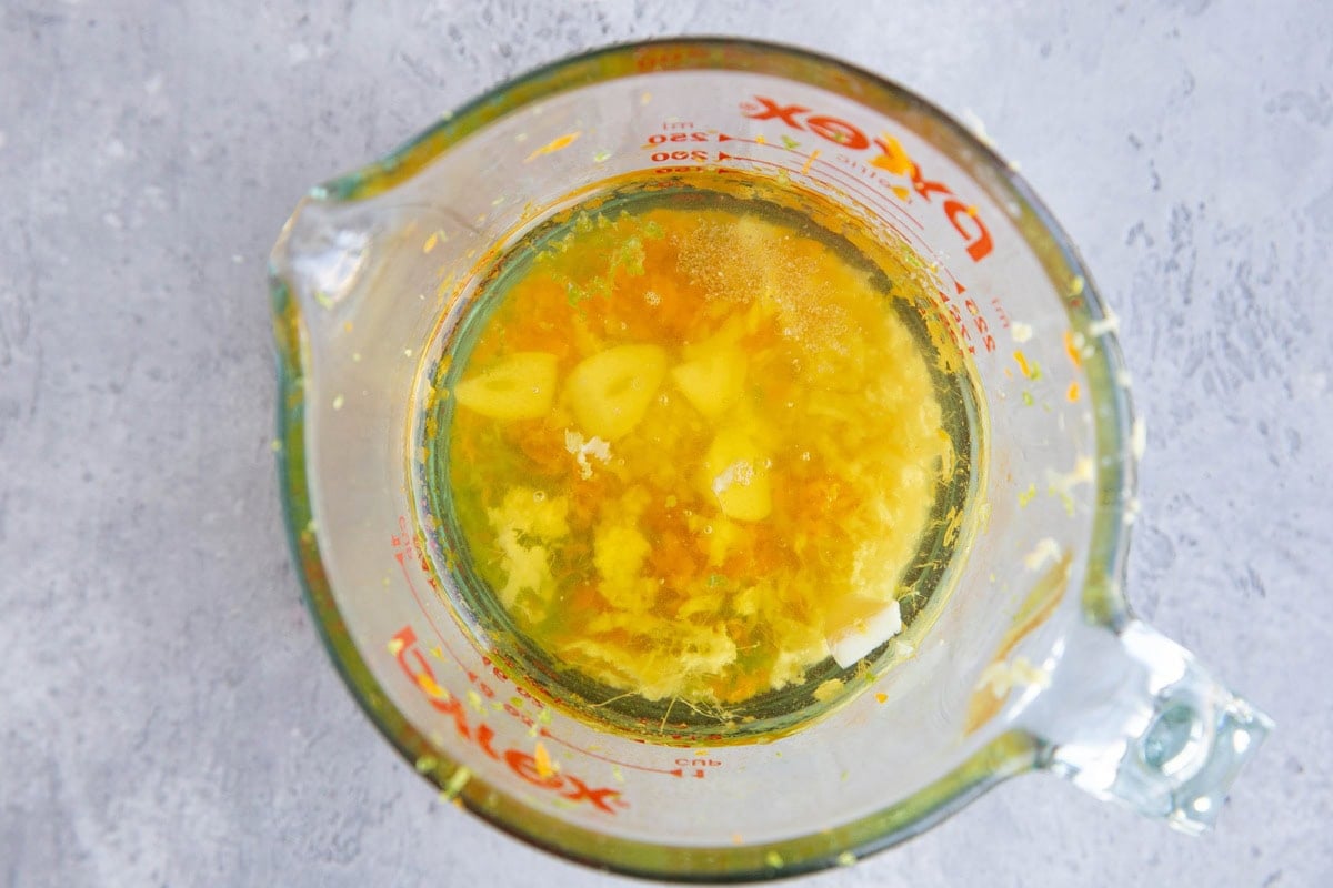 Measuring cup full of mojo sauce ingredients.