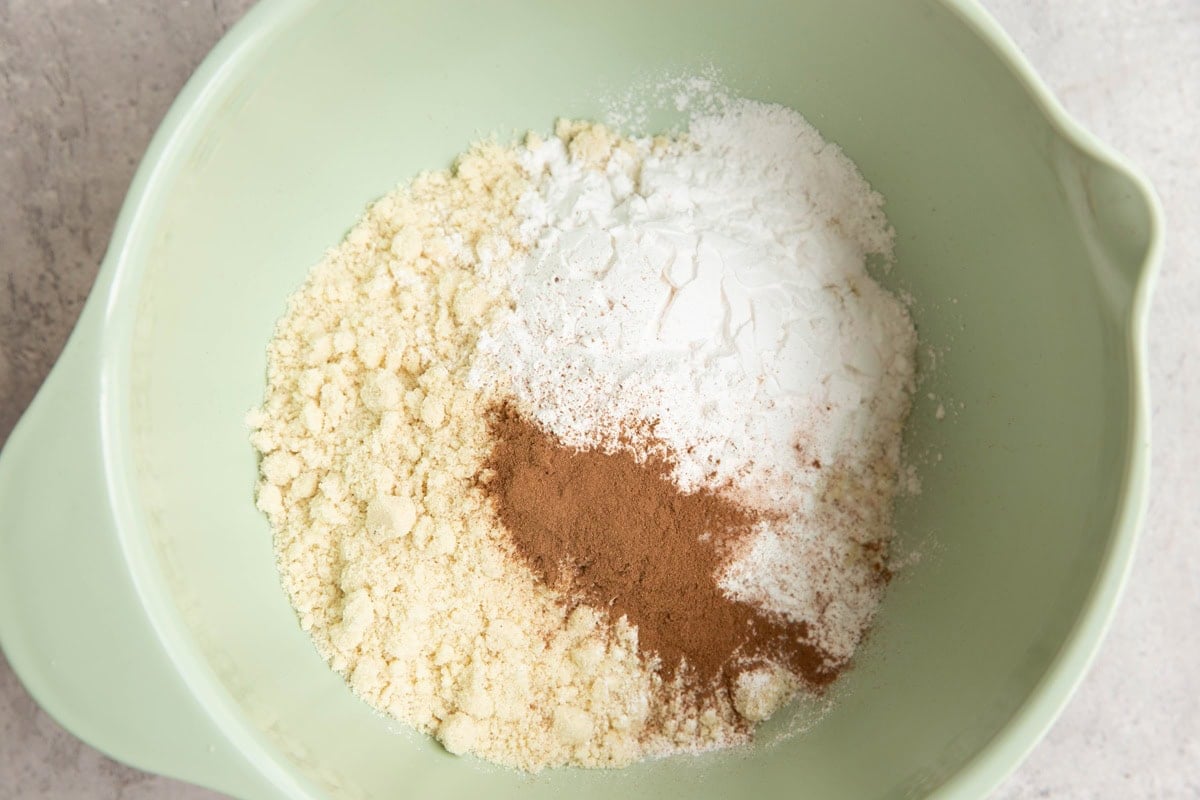 Almond flour, tapioca flour, ground cinnamon, and baking powder in a mixing bowl to be stirred together.