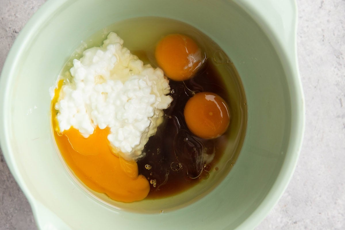 Cottage cheese, eggs, pure maple syrup, and oil in a mixing bowl to make muffins.