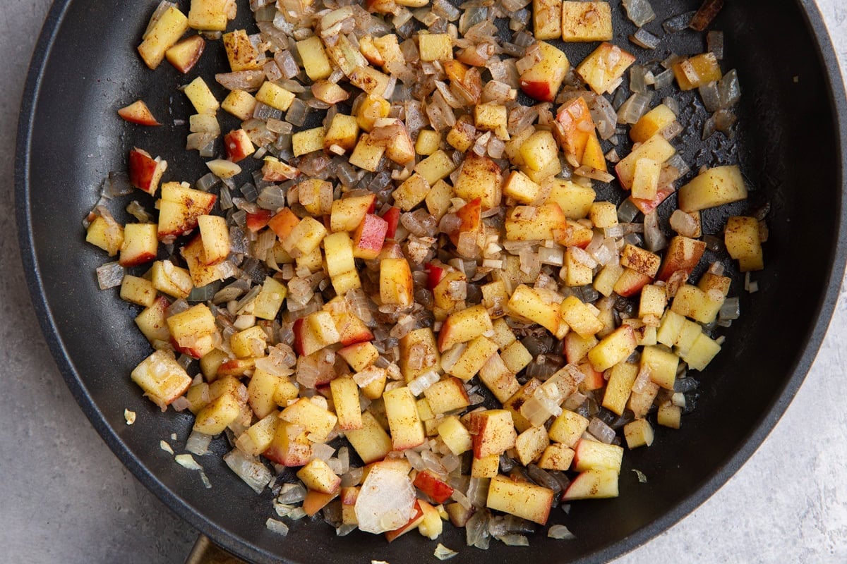 Skillet full of apple cinnamon and onion for chicken apple sausage.