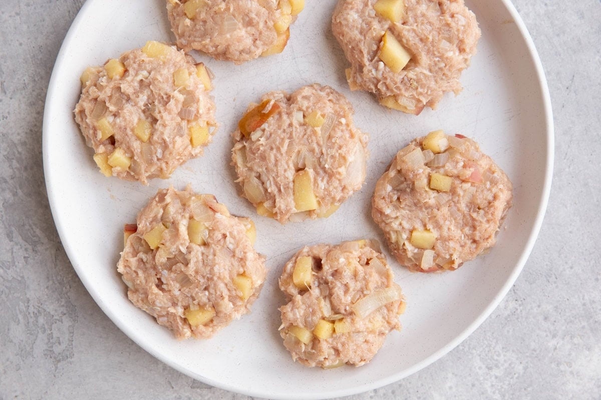 Plate with raw round chicken patties, ready to be cooked.