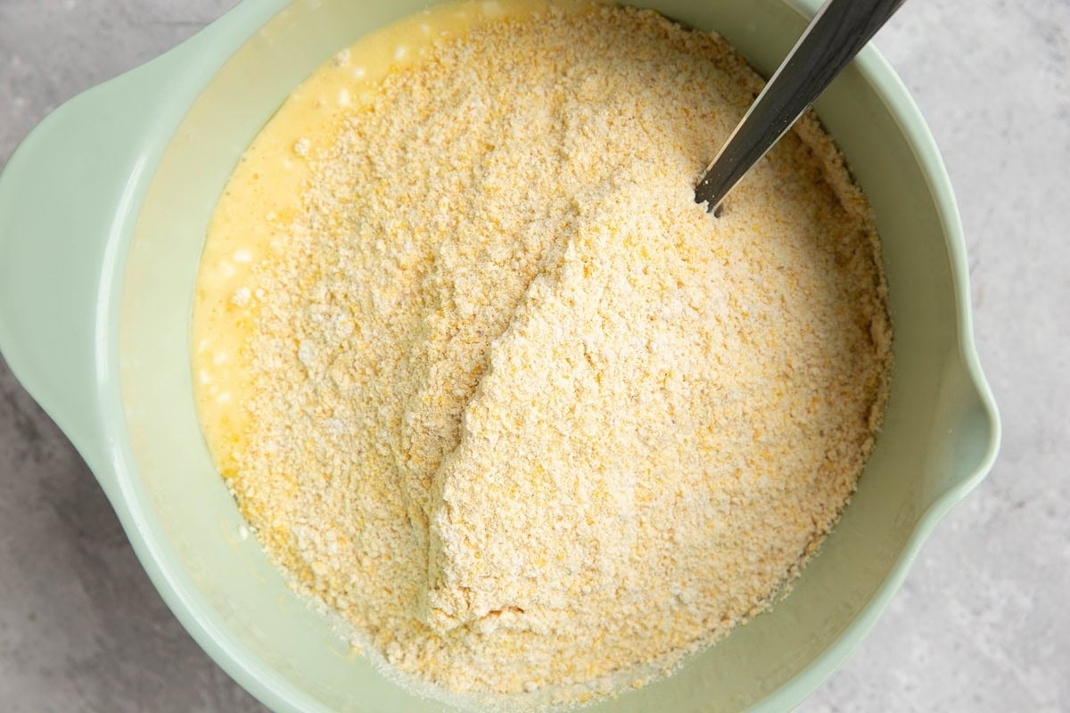 Mixing bowl with wet ingredients on the bottom and dry ingredients on top, ready to be mixed in.