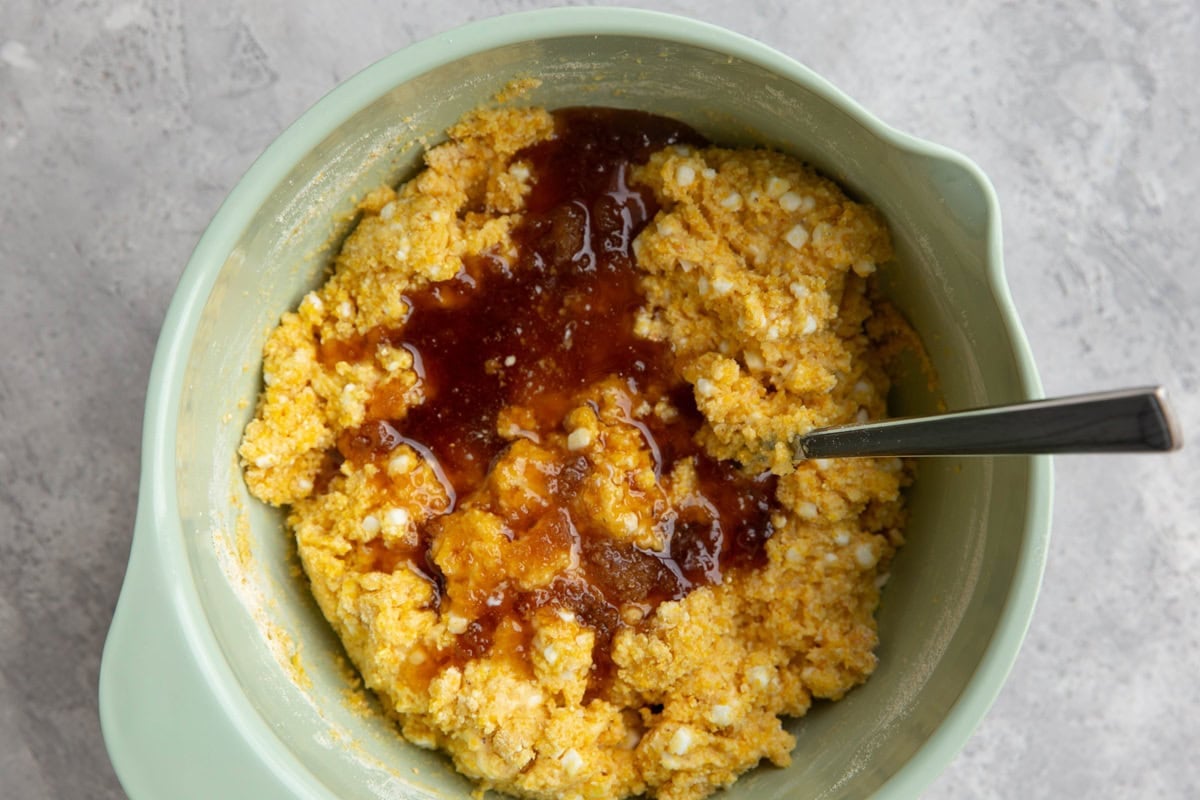 Mixing bowl full of cornbread batter with honey added in.