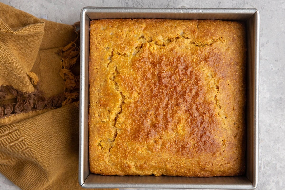 8-inch baking pan full of cornbread, fresh out of the oven and ready to serve.