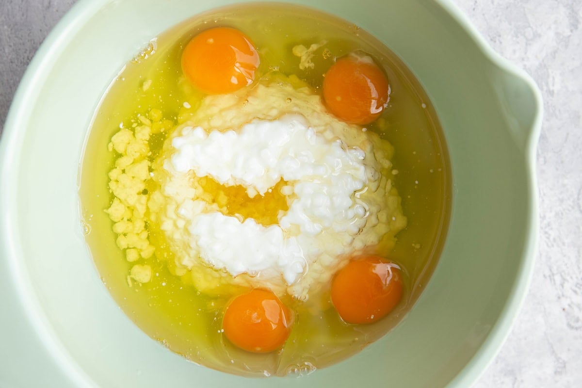 Large mixing bowl full of eggs, cottage cheese, and oil.