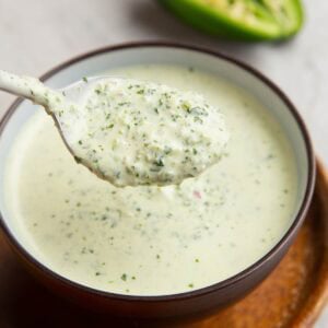 Bowl full of green sauce with a spoon scooping out some of the sauce.