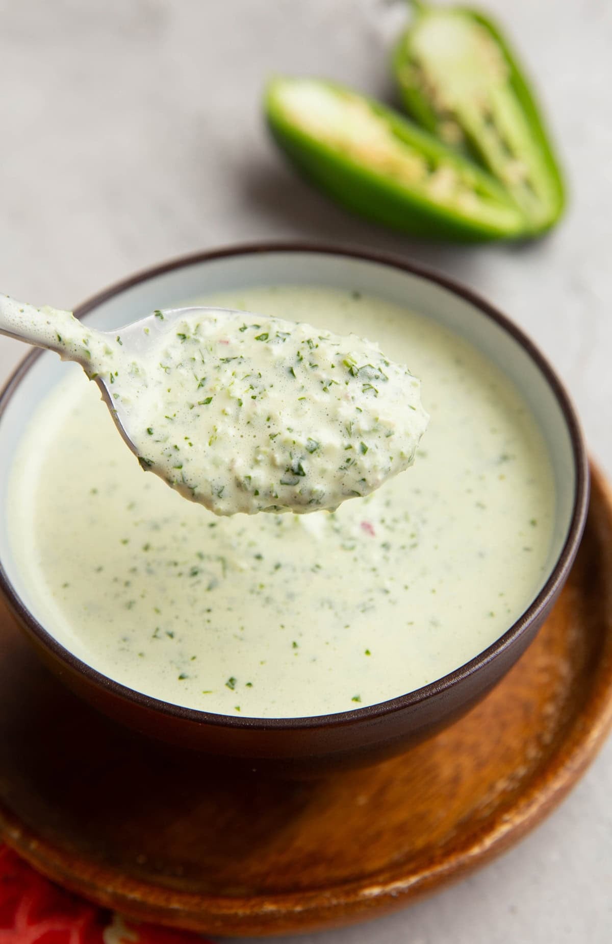Bowl full of green sauce with a spoon scooping out some of the sauce.