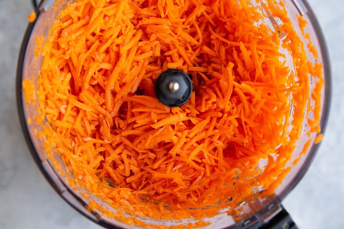 Food processor full of grated carrots.