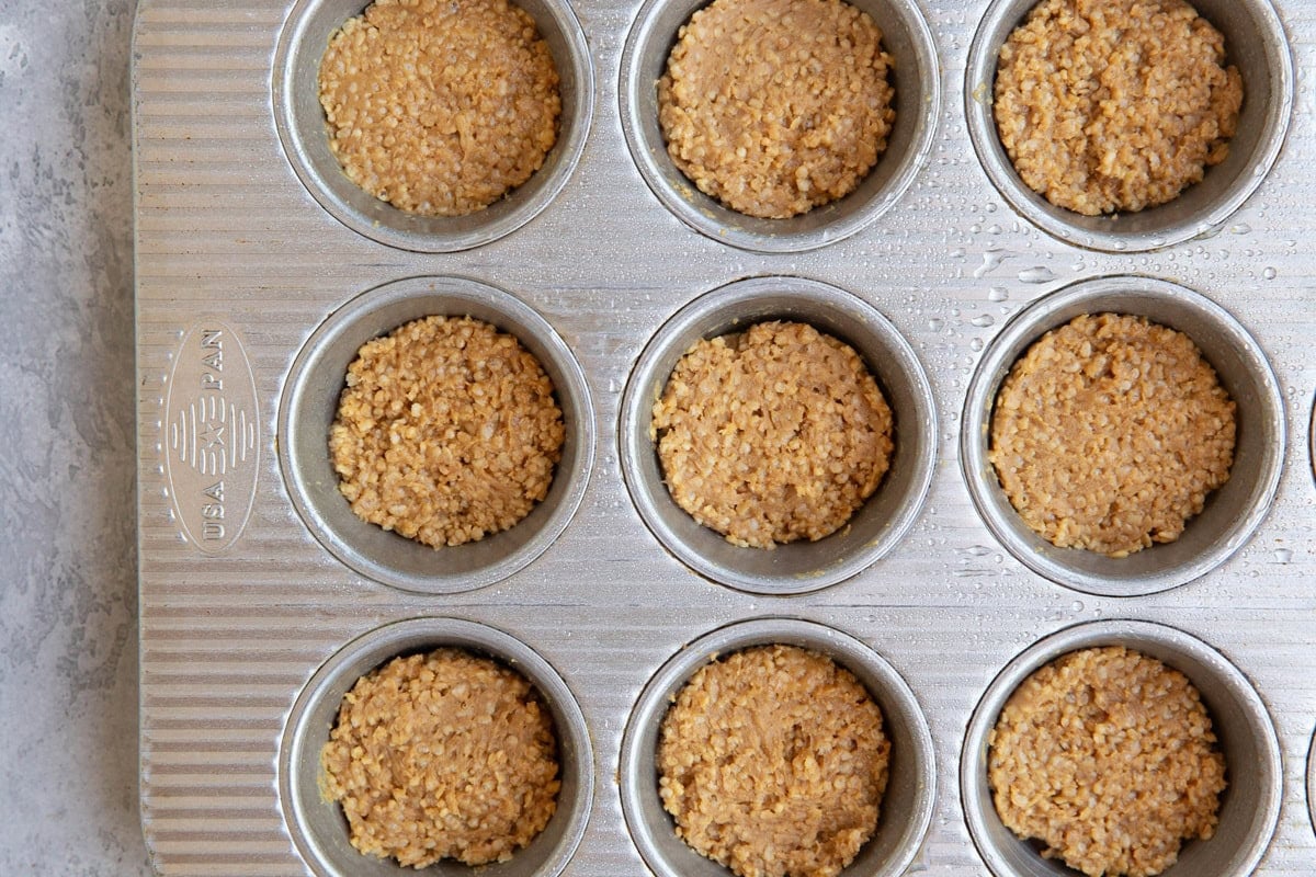 Muffin tin with peanut butter quinoa mixture inside.