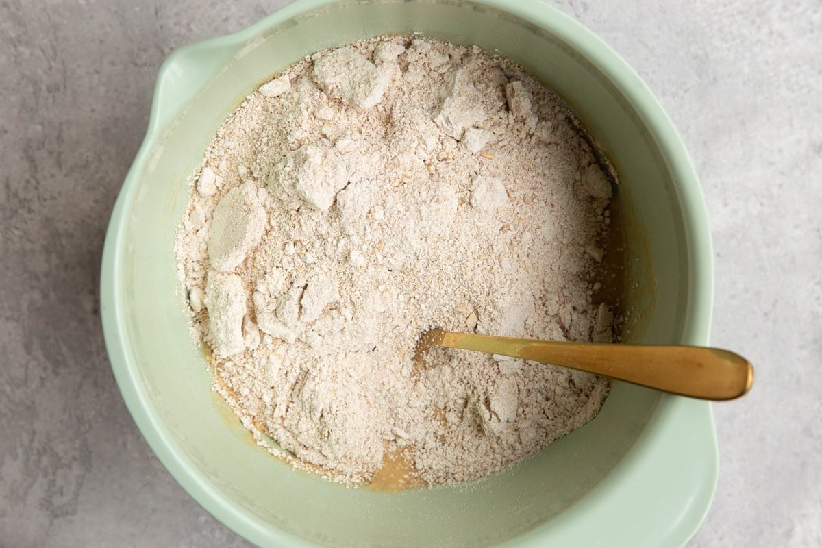 Mixing bowl with wet ingredients on the bottom and dry ingredients on top, ready to be mixed in.