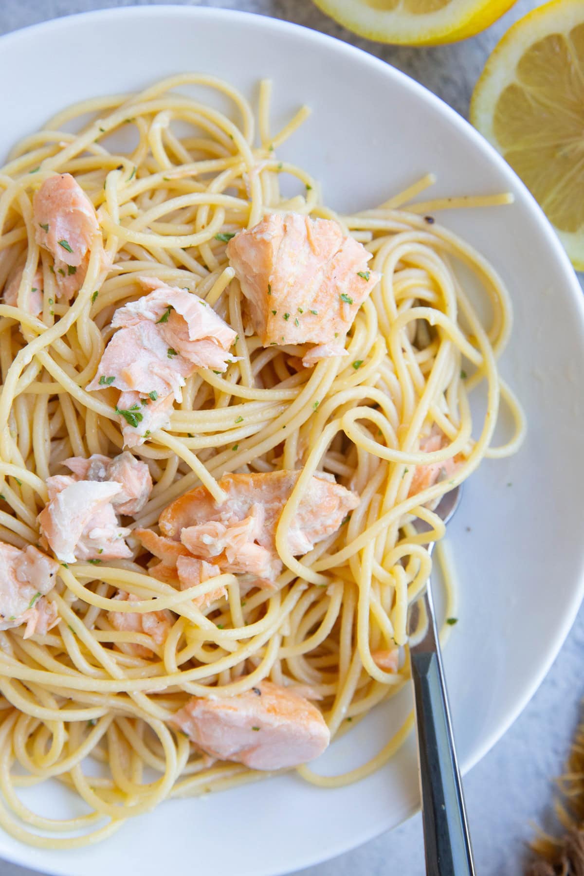 Plate with salmon pasta and a fork, ready to eat.