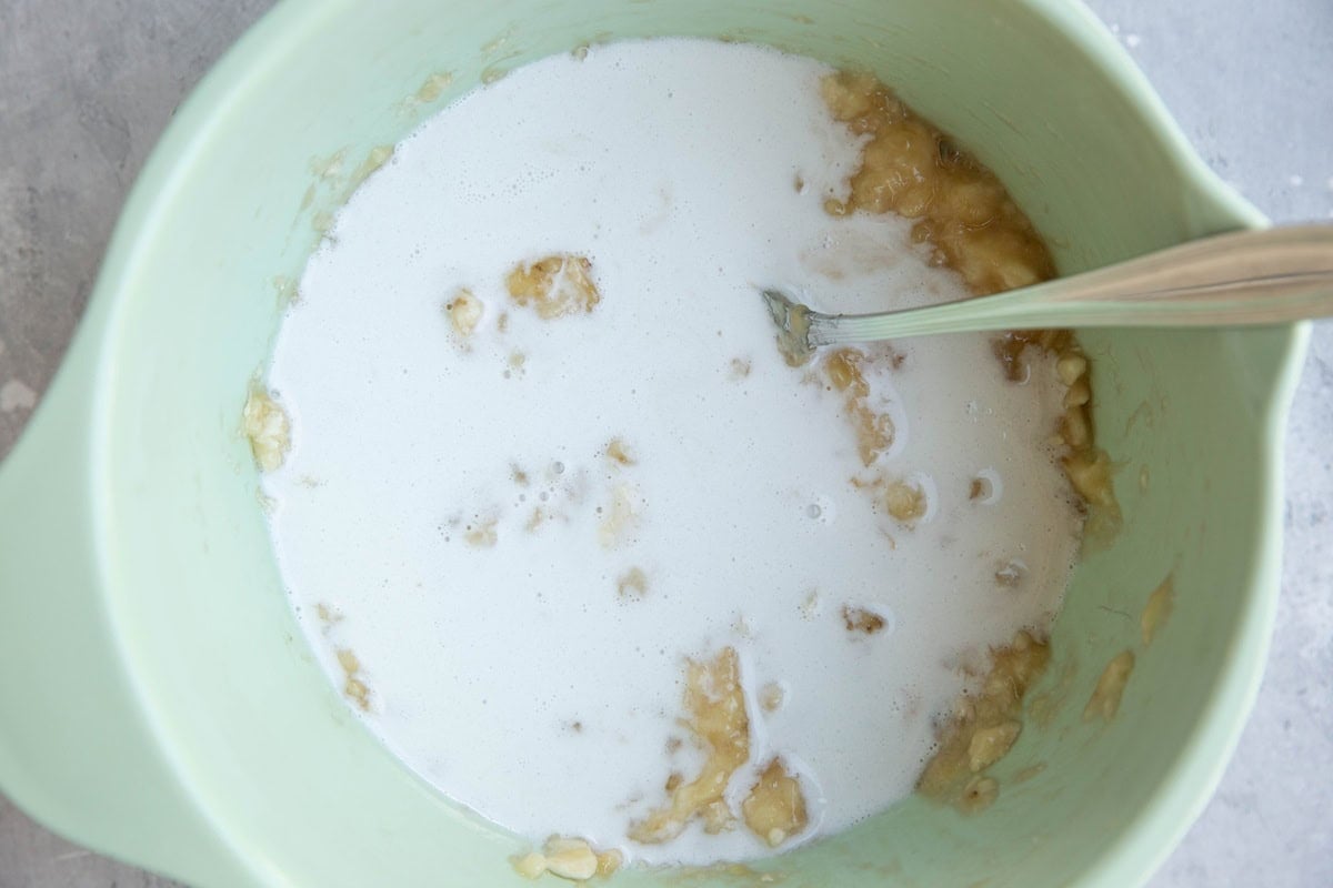 Mixing bowl full of mashed bananas, coconut milk, pure maple syrup and vanilla extract to make banana popsicles