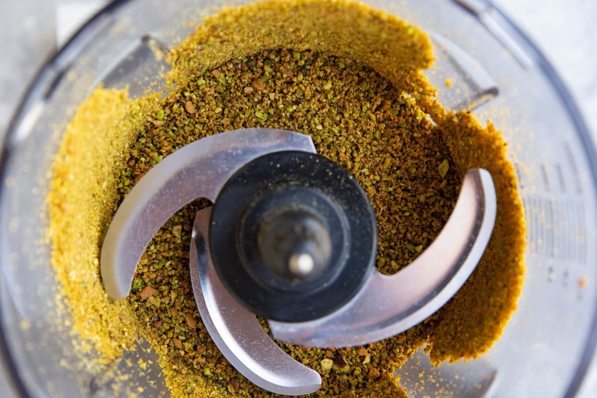 Ground pistachios in a food processor, ready to be used in cake.