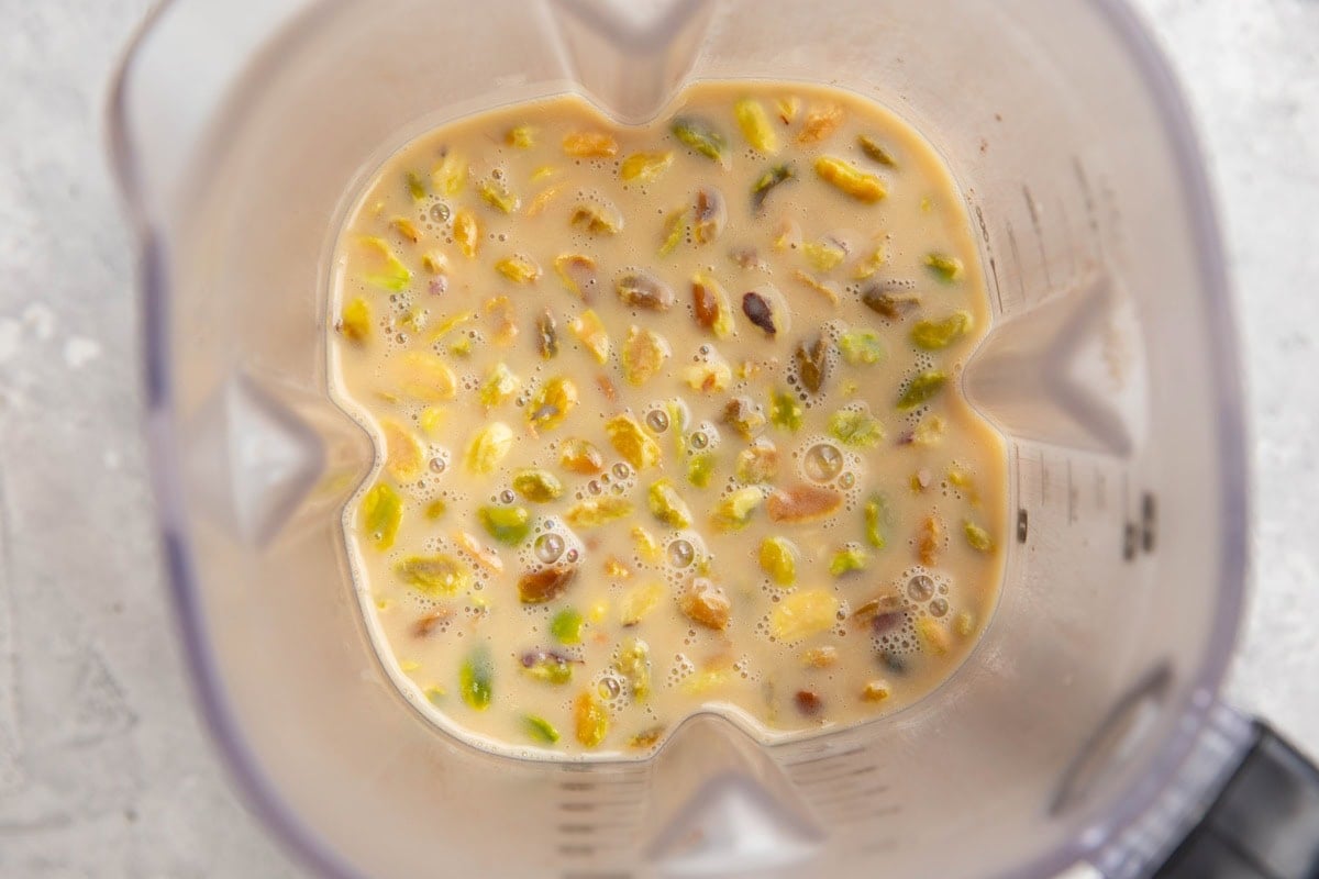 Blender with ice cream base and pistachios, ready to be bleneded.