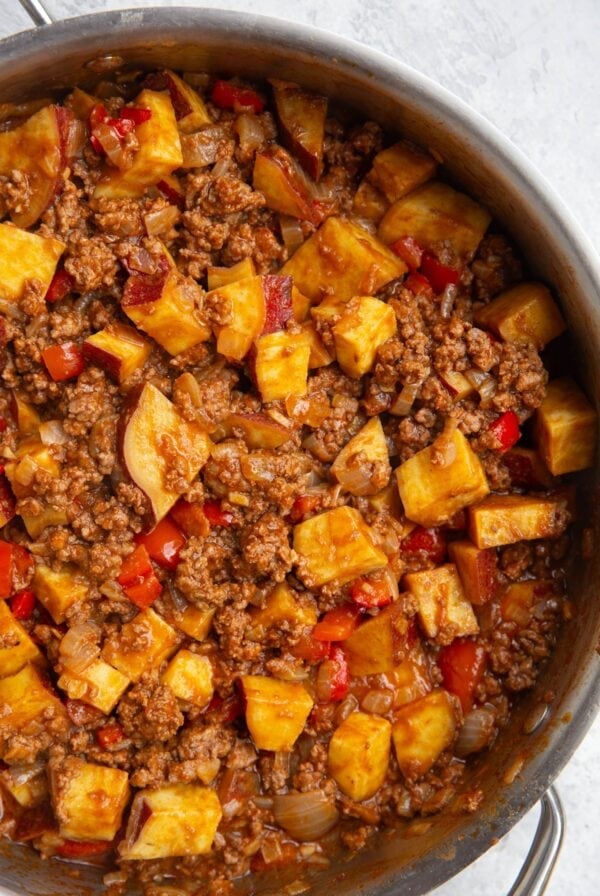 Skillet full of sweet potato sloppy joe mixture and cooked sweet potatoes, freshly made and ready to serve.