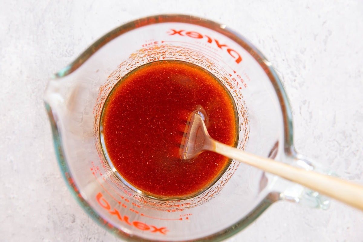 Marinade for halibut mixed up in a pyrex measuring cup with a fork.