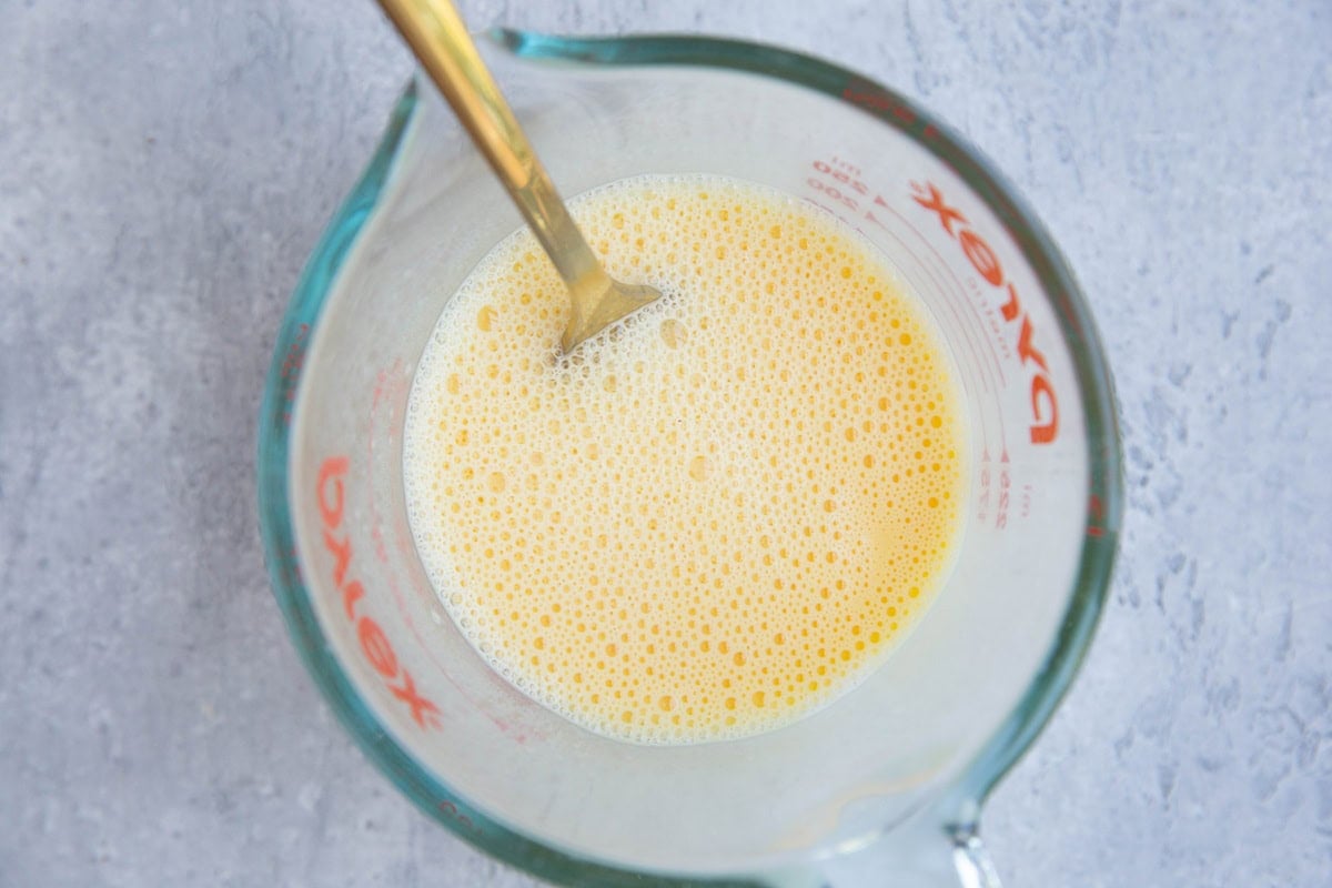 Pyrex measuring cup with milk and eggs mixed together.