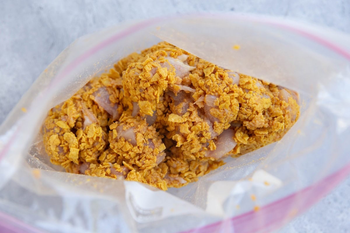 Zip lock bag full of chicken coated with crushed cornflakes.