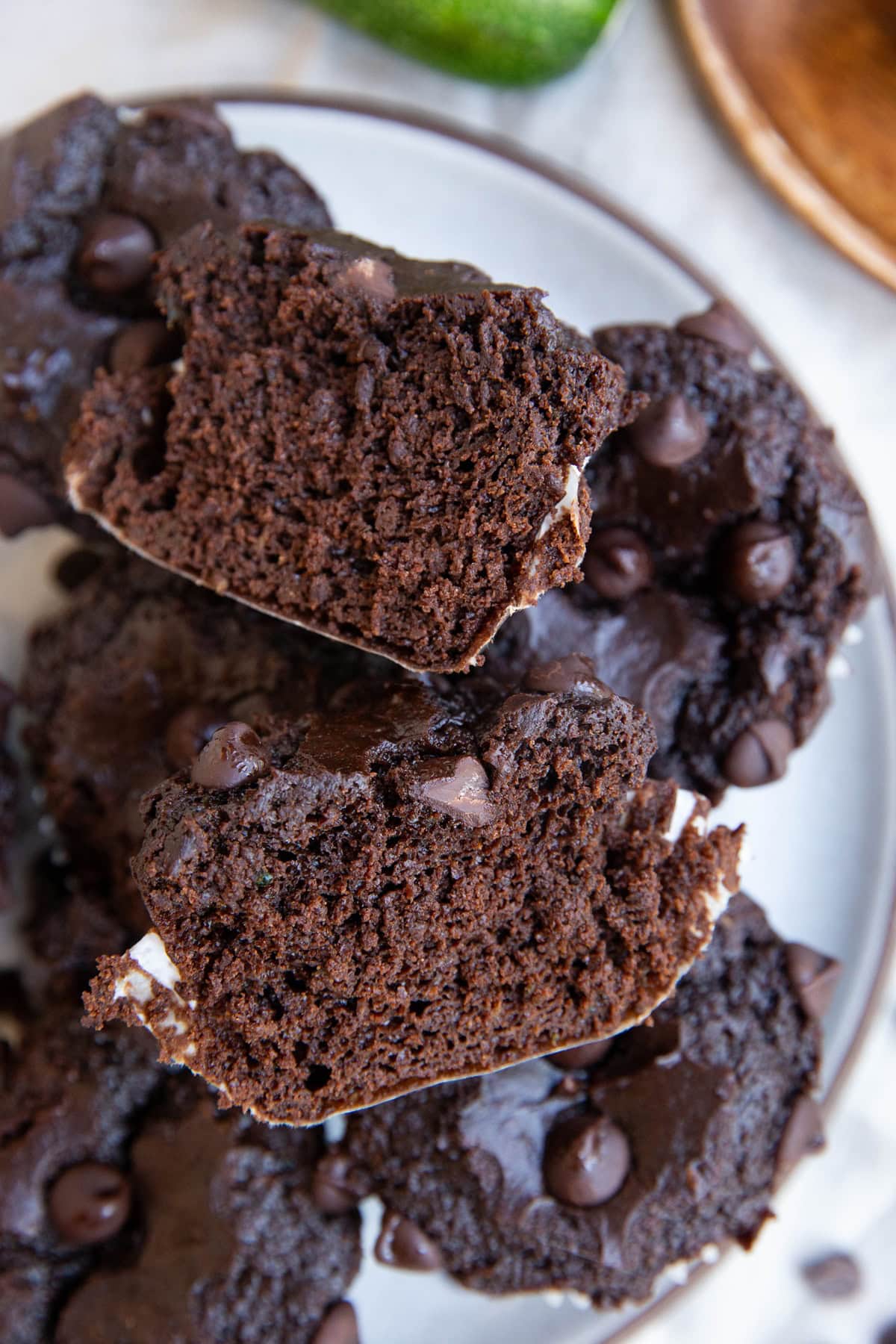 Plate of zucchini chocolate muffins with one cut in half to expose the inside.