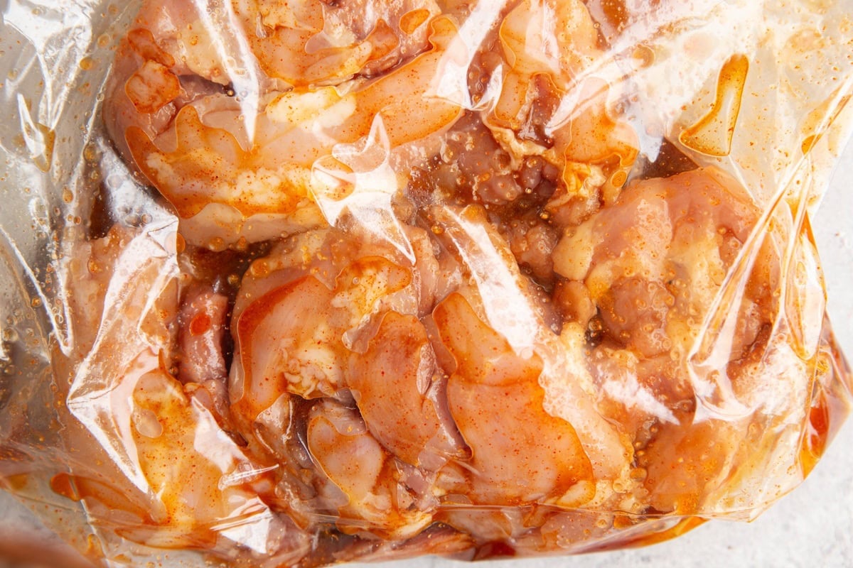 Zip lock bag full of boneless chicken thighs with marinade.