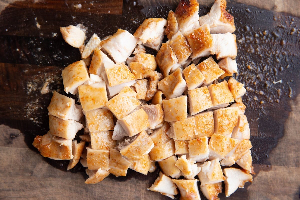 Chopped cooked chicken thighs on a cutting board, ready to use.