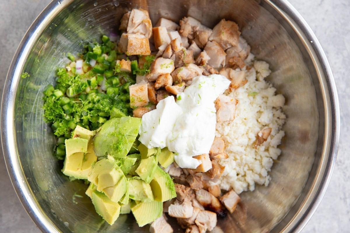 Stainless steel bowl with corn, chicken, cotija, avocado, jalapeno, lime, and Greek yogurt.