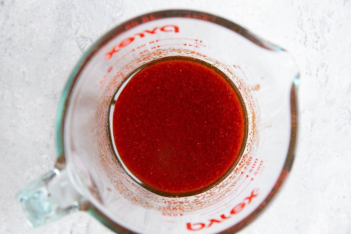 Measuring cup with chicken marinade mixed up and ready to use.