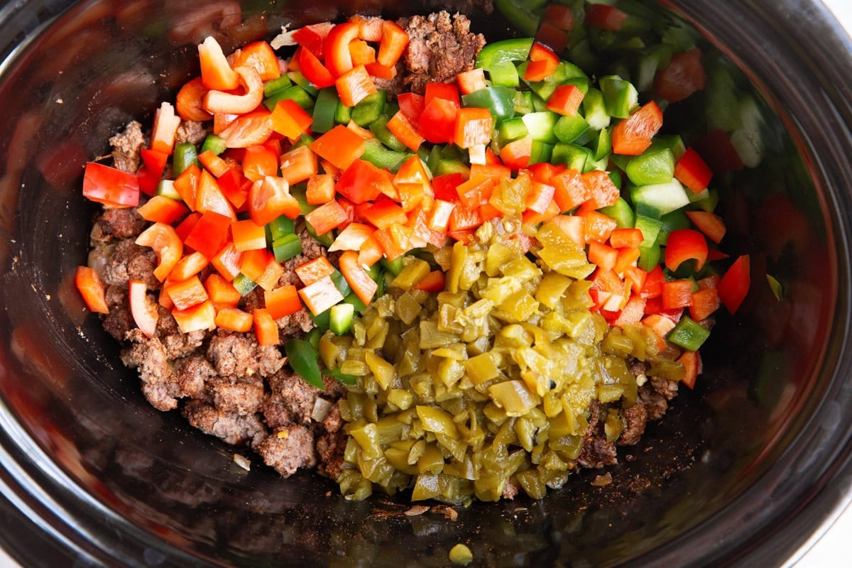 Slow cooker cull of browned ground beef, chopped bell peppers and diced green chiles.