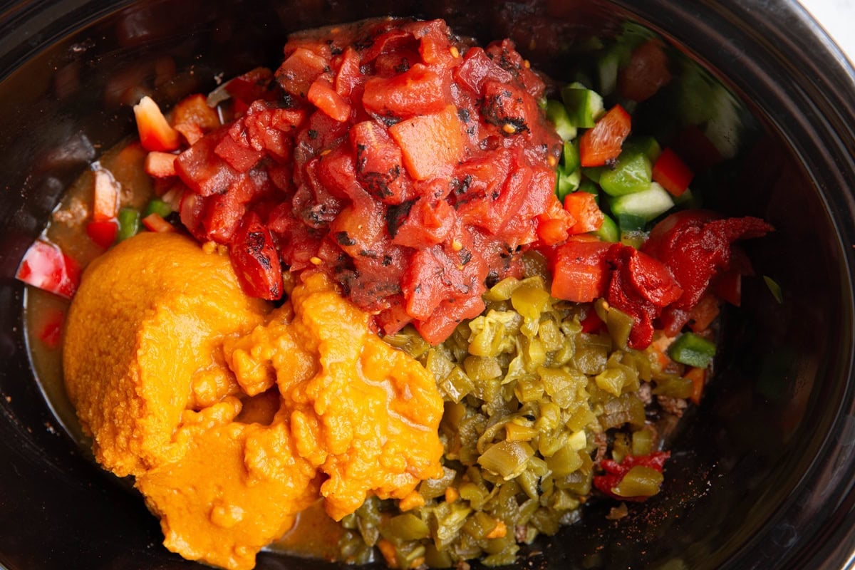 pumpkin puree and diced tomatoes on top of bell peppers and beef to make chili.
