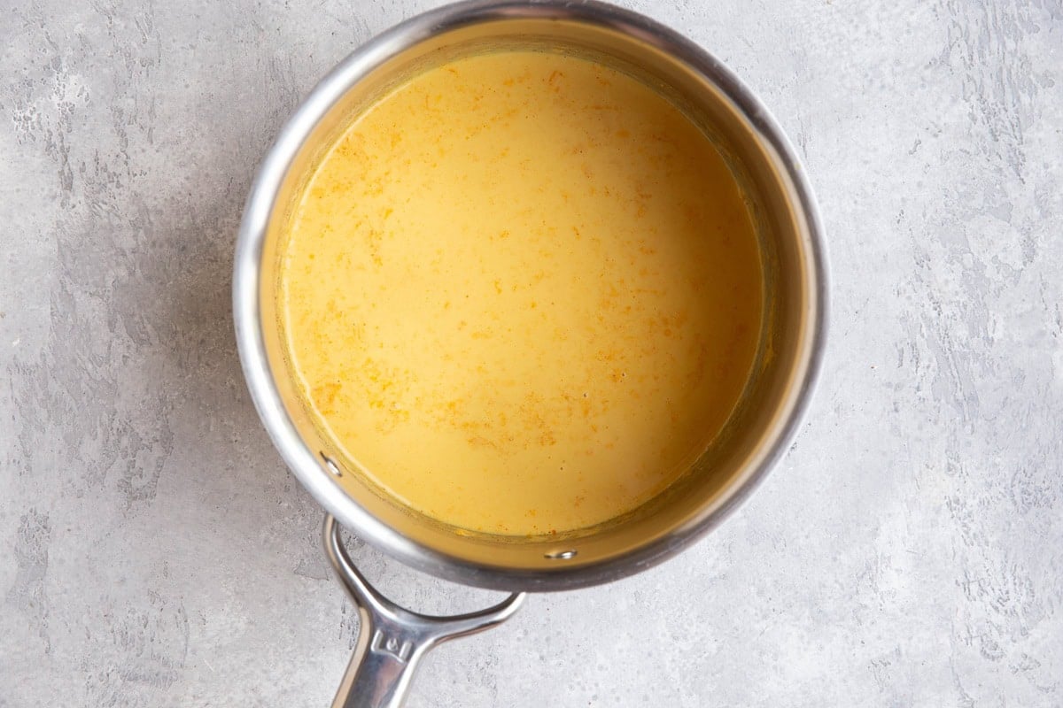 Coconut milk broth in a stainless steel saucepan to make broth bowls.