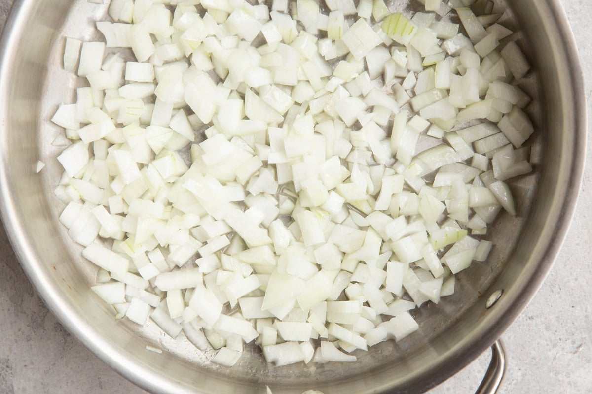 Sauteed onion in a stainless steel skillet.