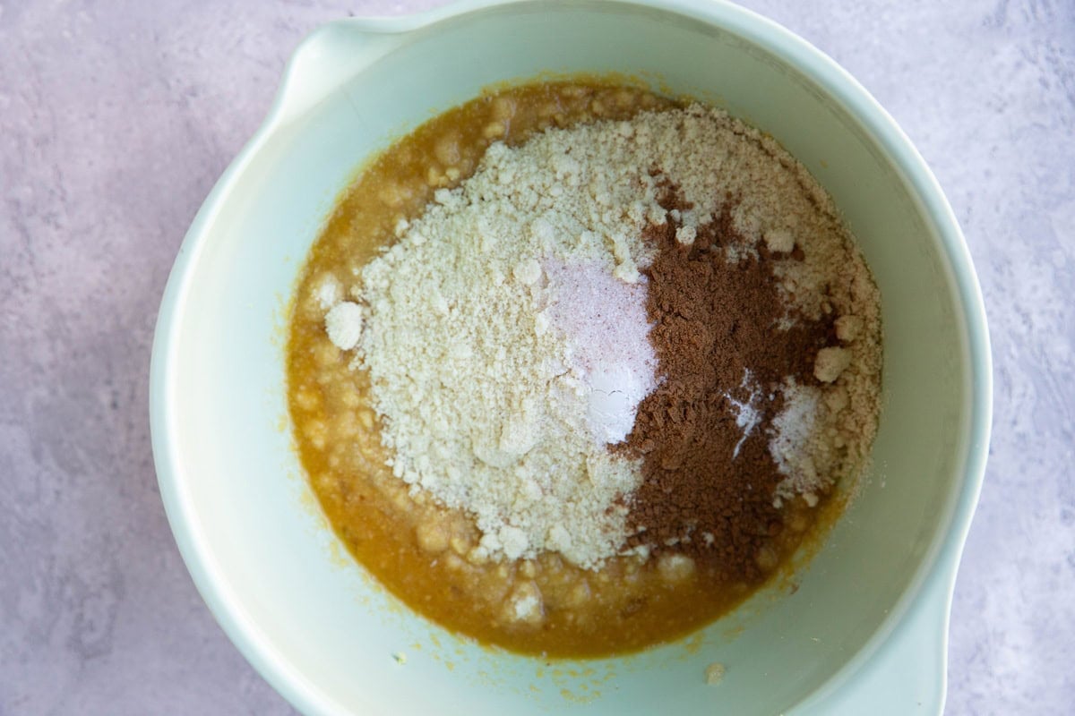 Mixing bowl with wet ingredients in the bottom and dry ingredients on top, ready to be mixed together.