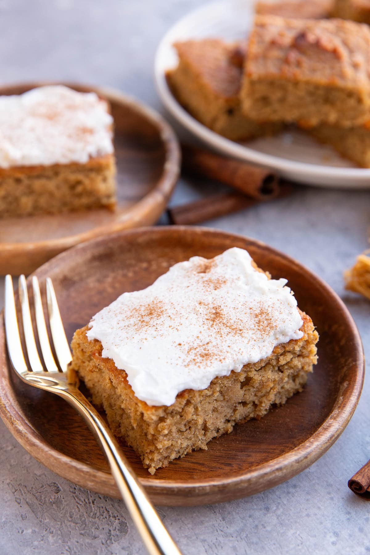 Wooden plates with spice cake slices and a plate of the rest of the cake slices in the background.